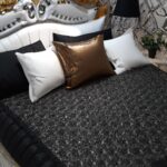 Stylowe łóżko z elegancką kołdrą i poduszkami, które podkreślają wystrój sypialni